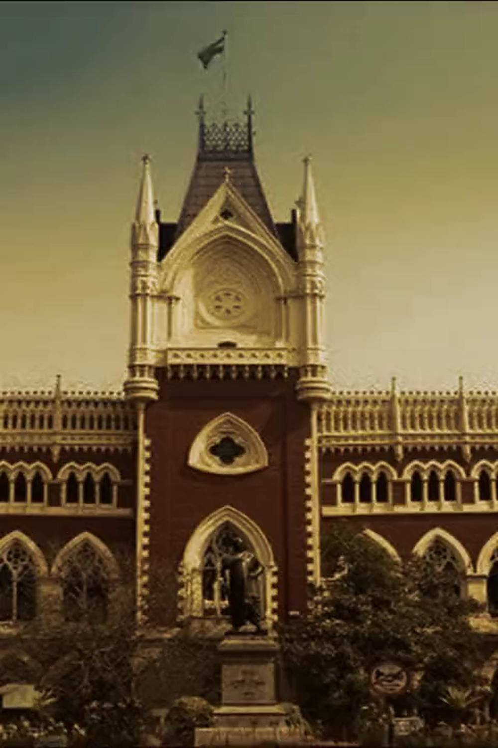 The central Gothic tower of the Calcutta High Court in Kolkata, its red brick and pale stone arcading rising against the sky.