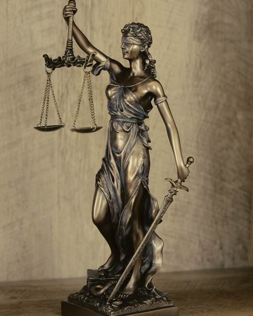 A bronze figure of Justice holding scales and a sword.